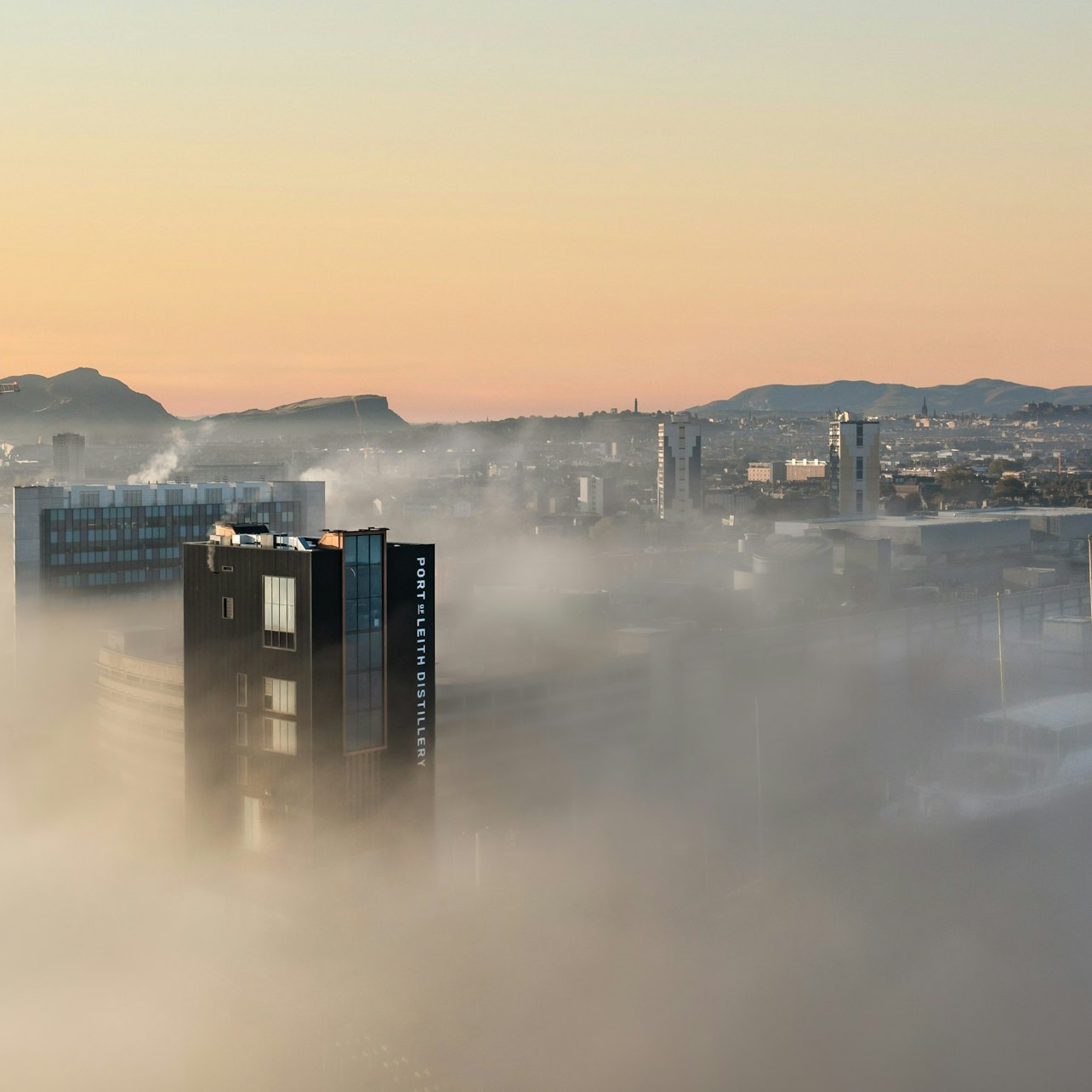 Discover the charm of Edinburgh's skyline shrouded in mist where the Port of Leith Distillery awaits inviting exploration of whisky-making secrets and breathtaking views.